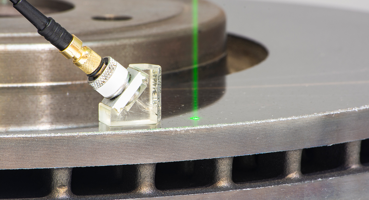 Laserstrahl und Sensor auf einer beschichteten Bremsscheibe.