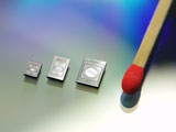 Drei 2D-Mikrospiegelchips im Größenvergleich mit einem Streichholz