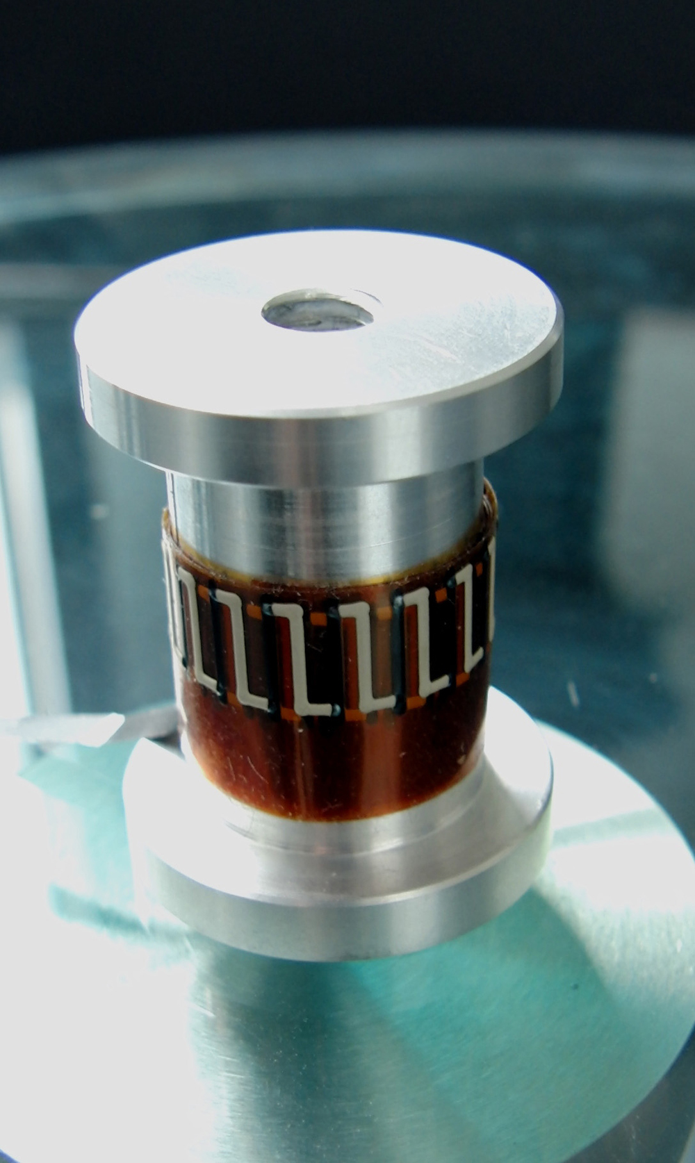 3D-Druck macht's möglich: Ein erster Demonstrator eines gedruckten thermoelektrischen Generators windet sich geschmeidig um ein Musterbauteil.