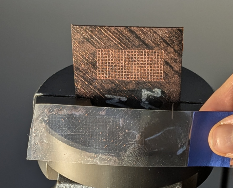 Nach Laser-Mikrostrukturierung thermisch aufgespritztes Kupfergitter auf kohlenstofffaserverstärktem thermoplastischem Laminat zeigt bei Ablöseversuchen eine feste Anbindung auf.