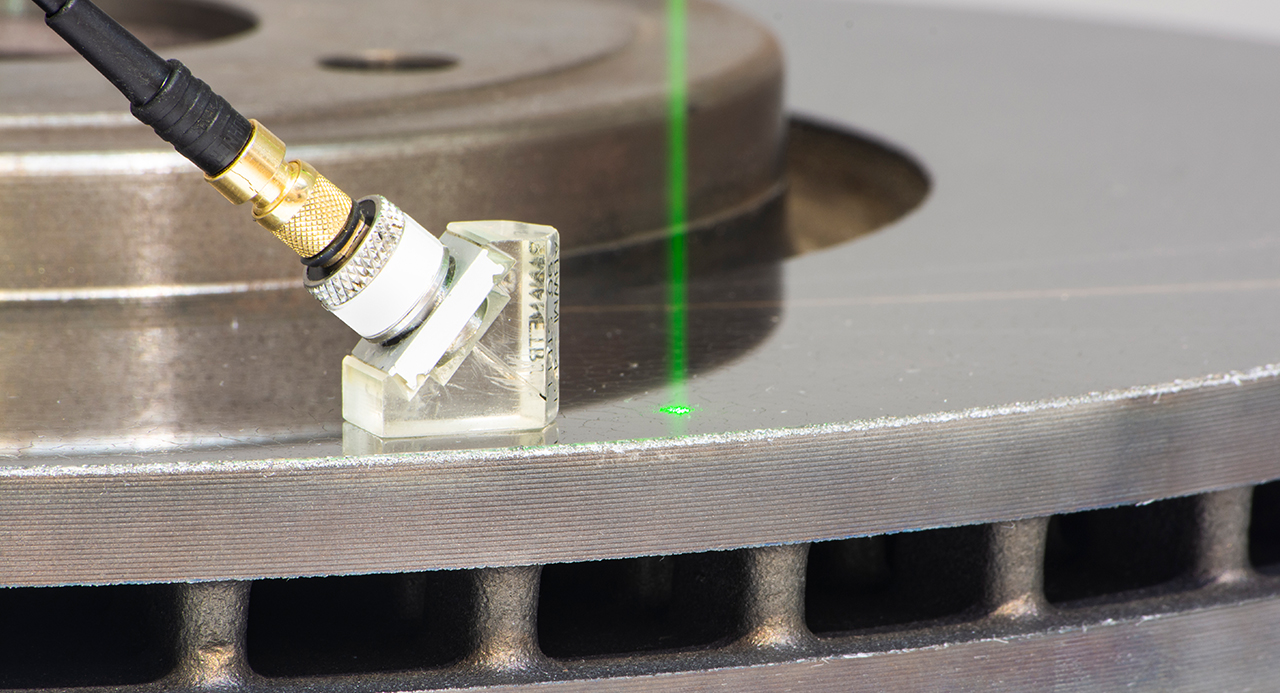 Laser beam and sensor on a coated brake disc. Laser beam and sensor on a coated brake disc.