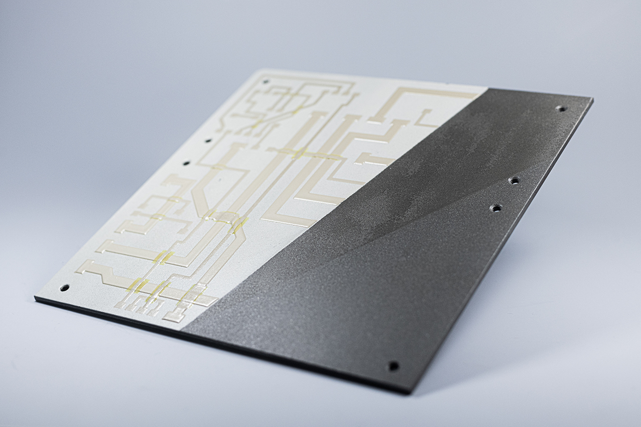 Researchers at Fraunhofer IWS, together with partners such as AIRBUS, are developing processes to fabricate conductive traces cost-effectively and reliably. To this end, they coat a metallic carrier plate with a ceramic coating, subsequently apply the printing paste for the conductive tracks and heat the finished printed demonstrator at high temperatures. Researchers at Fraunhofer IWS, together with partners such as AIRBUS, are developing processes to fabricate conductive traces cost-effectively and reliably. To this end, they coat a metallic carrier plate with a ceramic coating, subsequently apply the printing paste for the conductive tracks and heat the finished printed demonstrator at high temperatures.