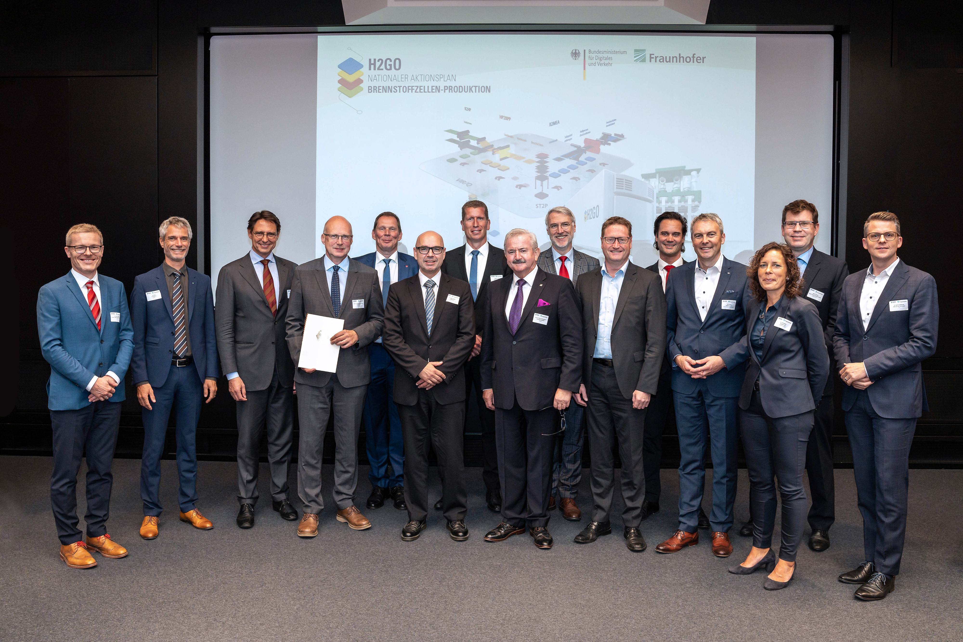 Prof. Reimund Neugebauer, President of the Fraunhofer-Gesellschaft and Prof. Welf-Guntram Drossel, Director of Fraunhofer IWU (with certificate), with representatives of industry (Alstom, Aumann, Capgemini, Schaeffler, Trumpf, EKPO) after the funding notification handover for H2GO at the Federal Ministry for Digital and Transport. Also in the picture: Kurt- Christoph von Knobelsdorff (Managing Director of NOW GmbH), Christoph Baum (Managing Director Fraunhofer IPT), Ulf Groos (Head of Fuel Cell Systems at Fraunhofer ISE) and Dr. Ulrike Beyer (Head of the Hydrogen Taskforce at Fraunhofer IWU).