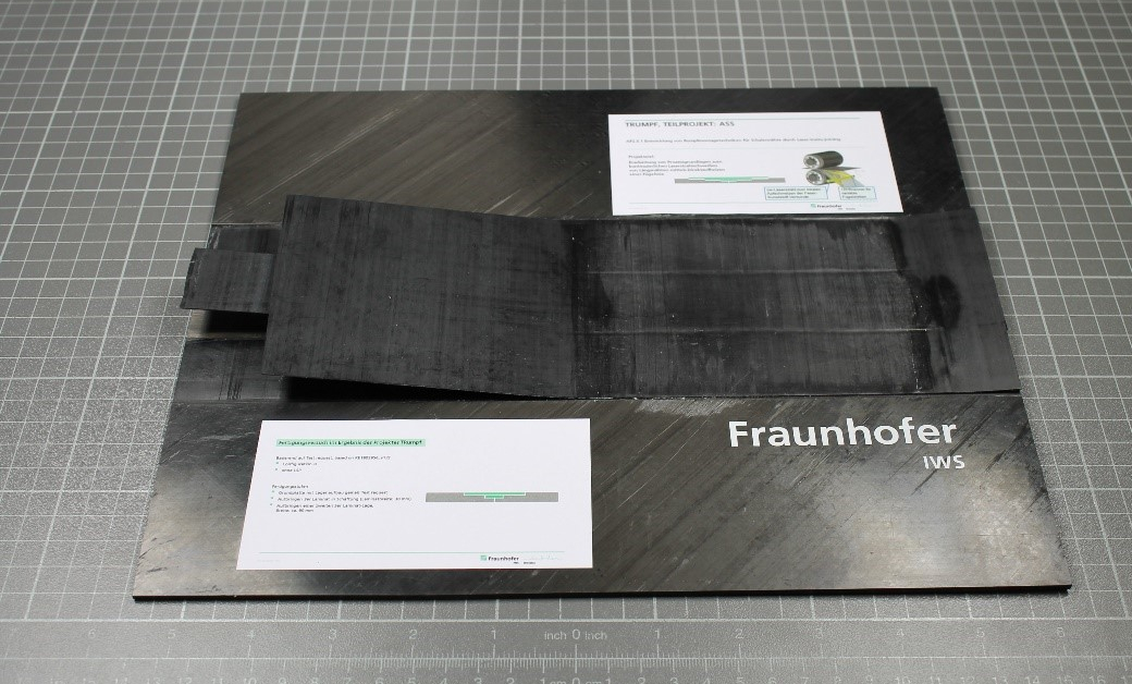 Joining of carbon fiber-reinforced PEKK by laser in-situ joining: three-layer laminate straps are deposited in a butt strap-design of the monolithic plate; post-consolidation is not required. Joining of carbon fiber-reinforced PEKK by laser in-situ joining: three-layer laminate straps are deposited in a butt strap-design of the monolithic plate; post-consolidation is not required.