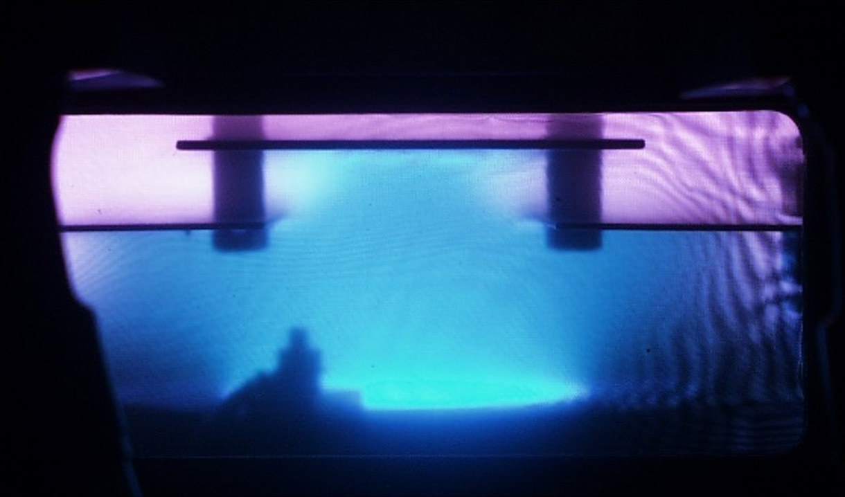 Arc-supported plasma cleaning in operation. The arc plasma below and the argon plasma above the shutter are clearly visible.